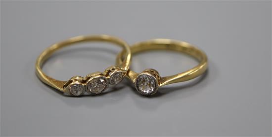 An 18ct and plat, solitaire diamond ring, size M/N, gross 2.5 grams and a yellow metal and three stone diamond ring.
